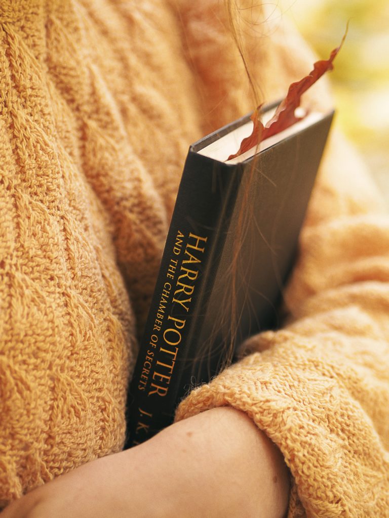 Femme tenant un livre Harry Potter